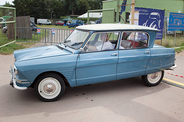 Hofheim-Diedenbergen, Germany - July 26, 2014: Male driver in a classic car Citroen Ami 6on a vintage car rally in Hofheim-Diedenbergen. Citroen Ami 6 was a compact car manufactured by French automobile manufacturer Citroen. Its design was based on the famous Citroen 2CV. Meeting of 2CV friends - Recontre nationale des amis de la 2CV.