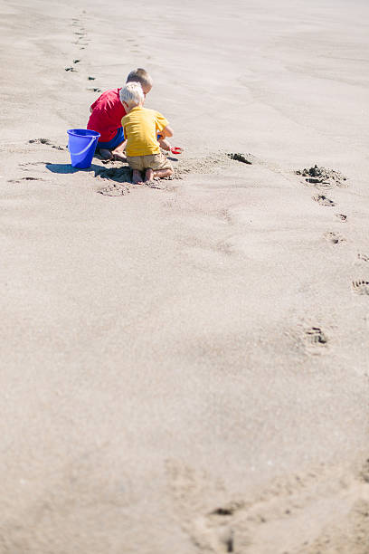 istock Two young boys build a sandcastle 503806364