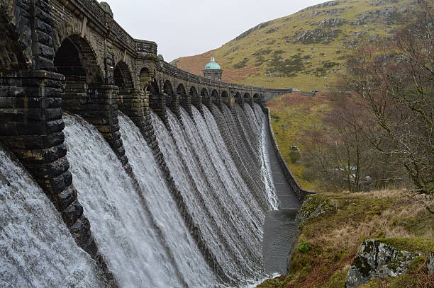 istock old stone dam, wales, water falling over 503812858