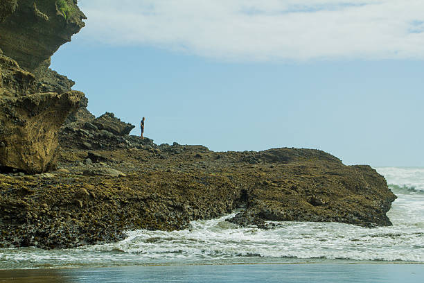 istock Lonely man on a stone shore with rough waves 503813724