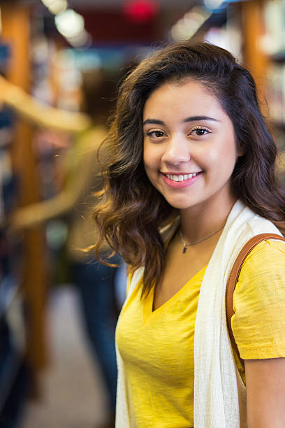 istock Pretty Hispanic college student standing in library 503816334