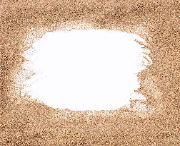 White frame surrounded by sand. From above
