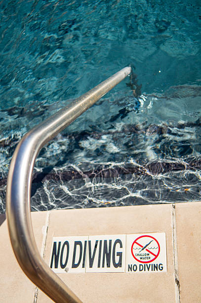 istock swimming pool stairs with No Diving sign 503818002