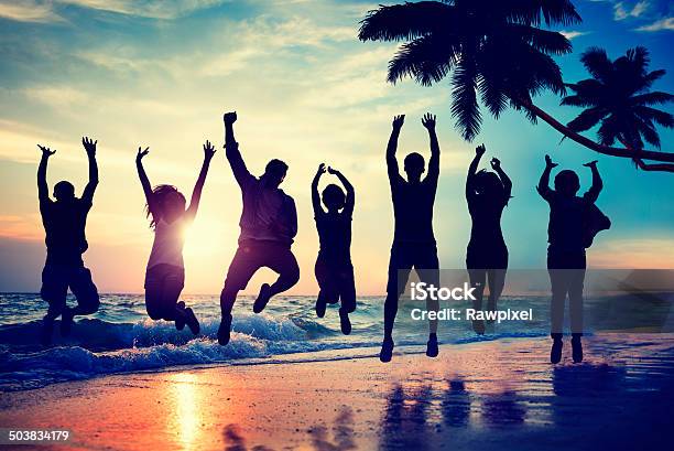 Group Jumping On Beach At Sunset Stock Photo - Download Image Now - Multiracial Group, In Silhouette, Beach