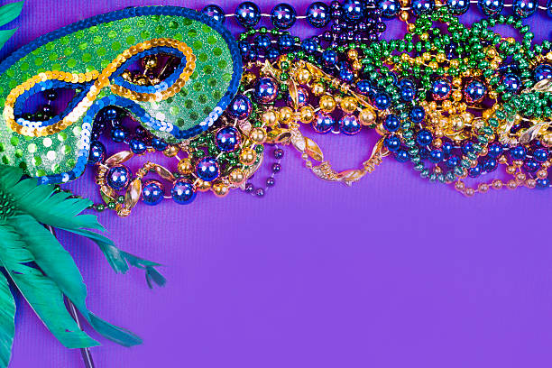 istock Mardi Gras background.  Purple, gold, green, mask, beads. 503837032