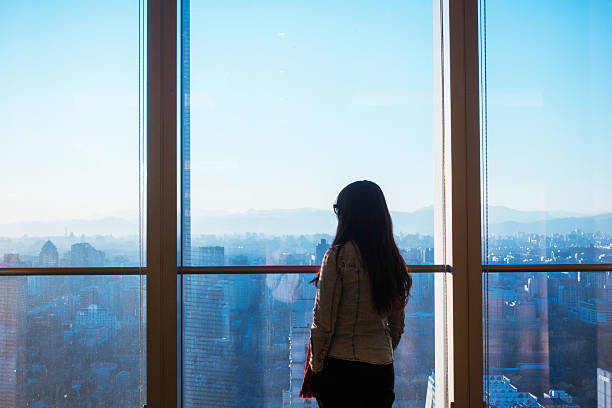 istock Woman looking cityscape through the window 503837738