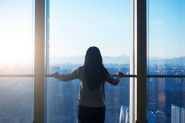 istock Woman looking cityscape through the window 503837818