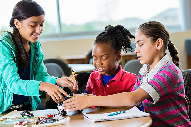 istock Diverse elementary school girls building robot in science class 503838620