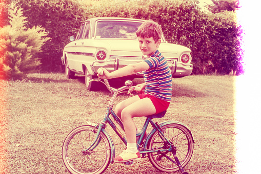 retro photo grom the seventies of a boy on a blue bicycle. Original photographic slide.
