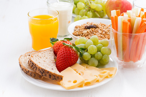 healthy and nutritious breakfast with fresh fruits and vegetables on white table, close-up, horizontal