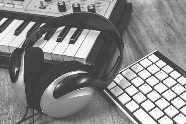 istock B&W headphone, synthesizer and computer keyboard on wooden table 503845744