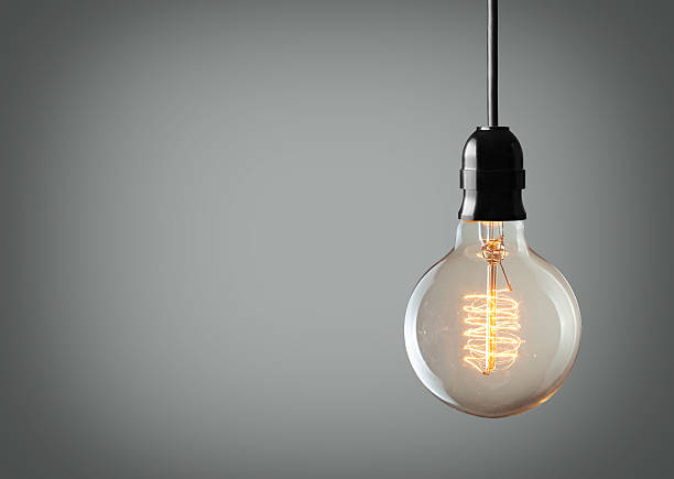 light bulb Vintage hanging light bulb over gray background light bulb filament photos stock pictures, royalty-free photos & images