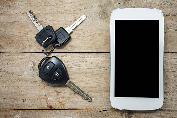 istock Mobile phone and car remote keys on wooden 503850644