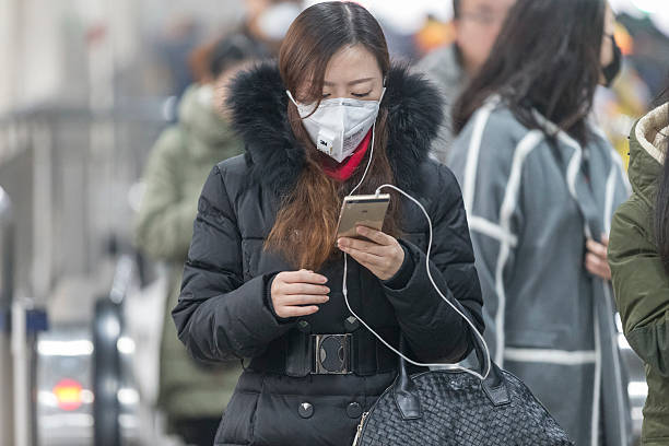 petite fille portant masque à la bouche avec filtre contre la pollution atmosphérique, beijing - beijing air pollution china smog photos et images de collection