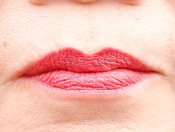 Mouth with red glossy woman lips. Closeup macro mouth of senior woman lips with red lipstick makeup. nub stock pictures, royalty-free photos & images