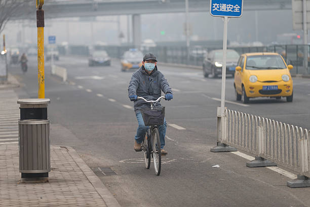 homem vestindo máscara de boca com filtro contra a poluição atmosférica, beijing - smog china beijing pollution - fotografias e filmes do acervo
