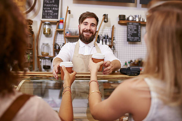 freundliche mann, kaffee für zwei frauen - women customer service representative service standing stock-fotos und bilder