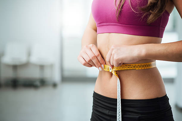 slim donna misura la sua vita sottile - dieta immagine foto e immagini stock