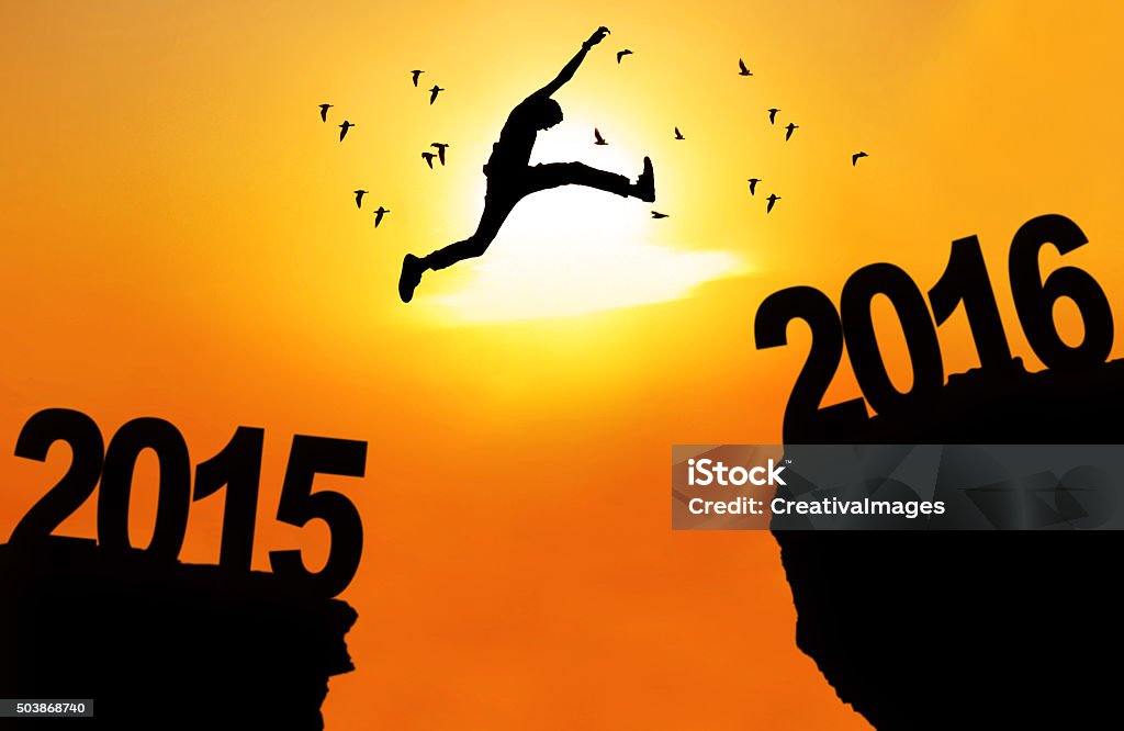 Man leap over cliff with numbers 2015 and 2016 Silhouette of young man jumping over a cliff with numbers 2015 and 2016 at sunset time 2015 Stock Photo