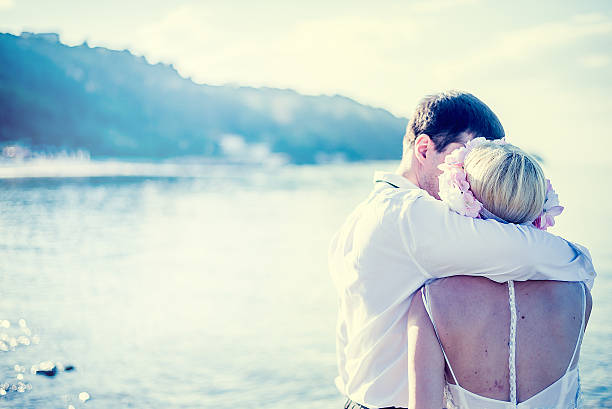 Young married couple kissing  on the beach.