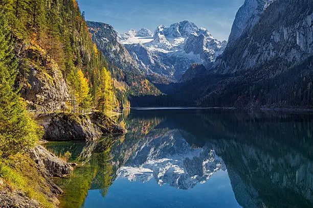 Beautiful view of idyllic colorful autumn scenery with Dachstein mountain summit reflecting in crystal clear Gosausee mountain lake in fall, Salzkammergut region, Upper Austria, Austria