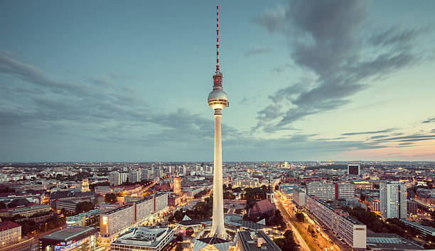 Berlin skyline panorama with famous TV tower at Alexanderplatz a Aerial view of Berlin skyline with famous TV tower at Alexanderplatz and dramatic cloudscape in twilight during blue hour at dusk with retro vintage Instagram style nostalgic pastel toned filter effect, Germany east berlin photos stock pictures, royalty-free photos & images