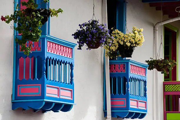 Colorful blue and red house front with flowers on balcony in Salento, Colombia