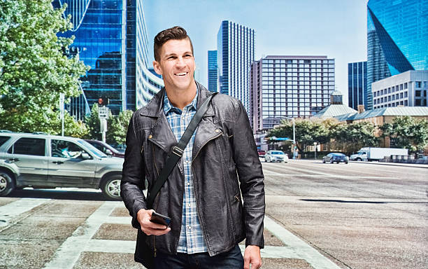 istock Smiling man holding mobile outdoors 503875024