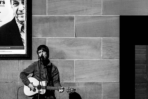 Glasgow, Scotland UK - April 12, 2015: a street performer playing guitar music and sings in the Buchanan street in the center of Glasgow Scotland 2015