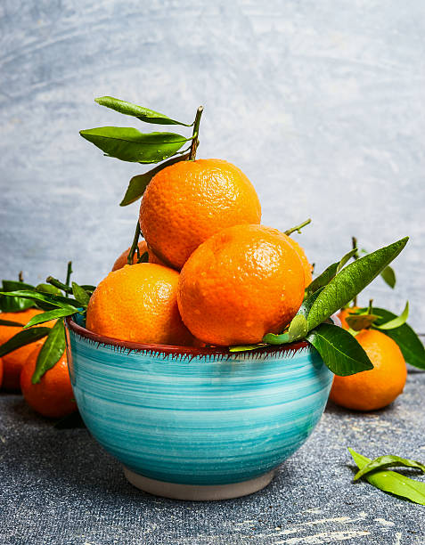 istock Blue bowl with Tangerines with green leaves, side view 503887170