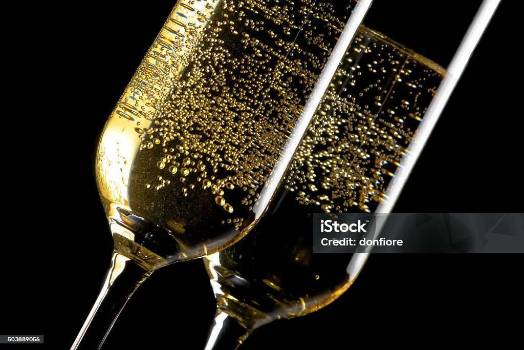 pair of flutes of champagne with golden bubbles detail of a pair of flutes of champagne with golden bubbles on black background Alcohol - Drink Stock Photo