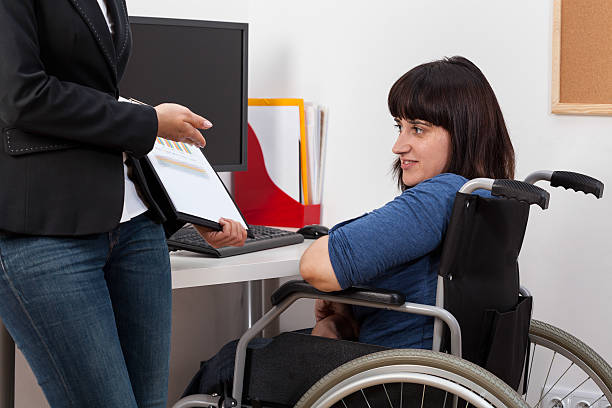 istock Woman on wheelchair analyzing charts with her boss 503889361