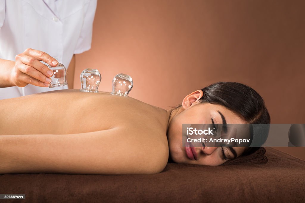Young Woman Getting Cupping Treatment Young Female Lying On Front Receiving Cupping Treatment On Back Vacuum Cupping Stock Photo