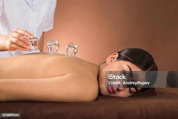 Young Woman Getting Cupping Treatment Stock Photo - Download Image Now - Vacuum Cupping, Acupuncture, Massaging