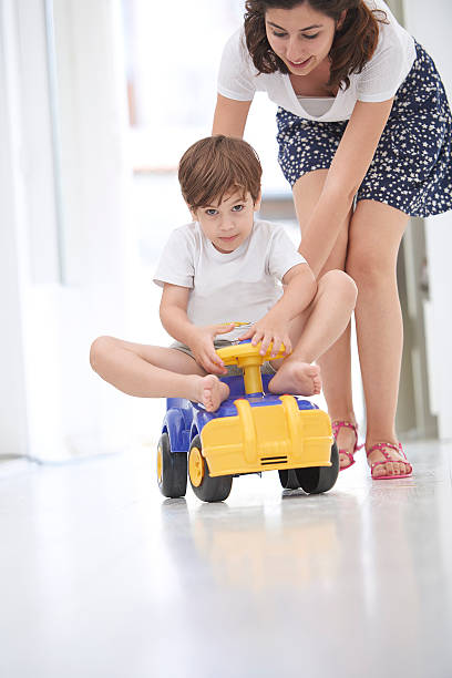 istock Mother pushing daughter in toy car 503890362