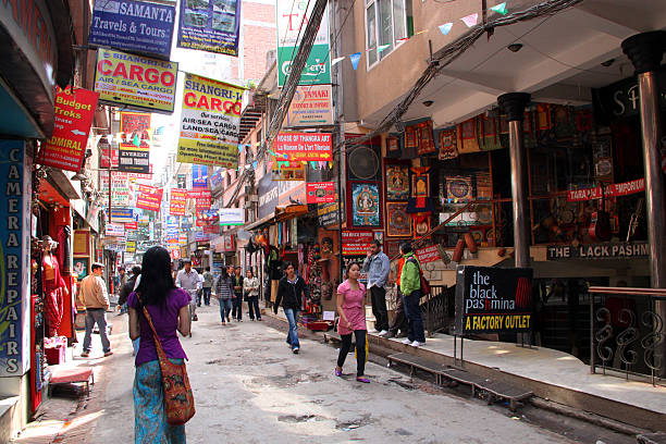 Kathmandu, Nepal - March 21, 2011: Visitors and tourists walk along a street in central Kathmandu, the capital city of Nepal. The city has a population of over 3,000,000 inhabitants and has an elevation of 1,400 metres (4,600 ft) in the bowl-shaped Kathmandu Valley. The city is the gateway to tourism in Nepal, home of the Himalayas.