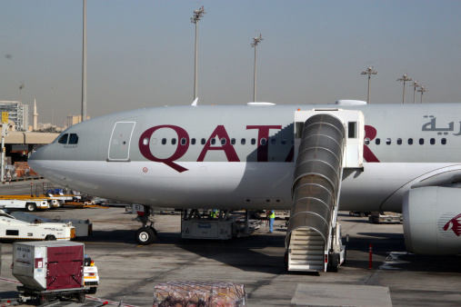 Doha, Qatar - March 22, 2011: Qatar Airways planes lined up at the terminal at the Doha International Airport in Qatar. The airport was a major hub in the country until Hamad International Airport opened in April 2014.