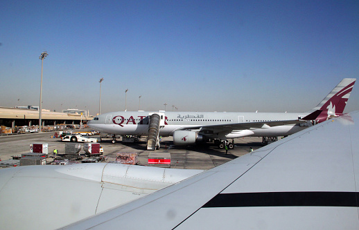Doha, Qatar - March 22, 2011: Qatar Airways planes lined up at the terminal at the Doha International Airport in Qatar. The airport was a major hub in the country until Hamad International Airport opened in April 2014.