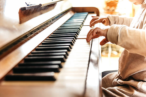 istock little girl is playing on old piano 503891490