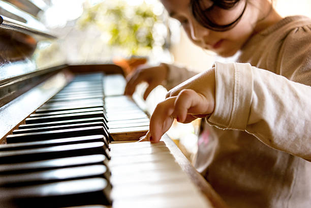 istock cute little girl playing on old piano 503891564