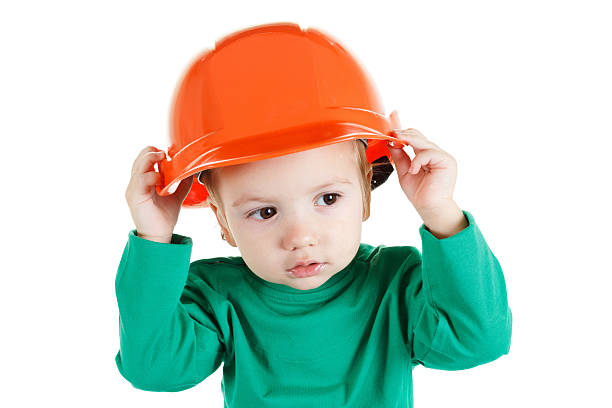 istock Little child plays with construction protective helmet  on white background. 503893262