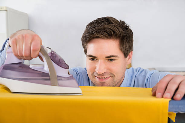 istock Young Man Ironing T-shirt With Electric Iron 503893748