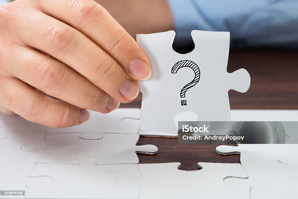 Person Hand Holding Puzzle With Question Mark Close-up Of Person Hand Holding Puzzle With Question Mark Sign Mystery Stock Photo