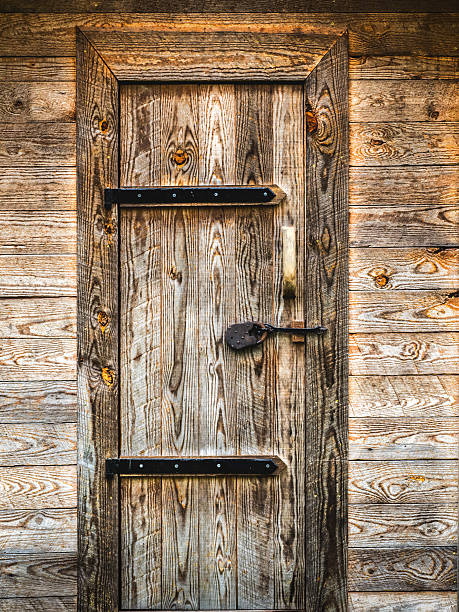 wooden door with hinges, latch and wood frame in outhouse building