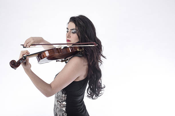 istock Young beautiful woman playing the violin over white background 503912672