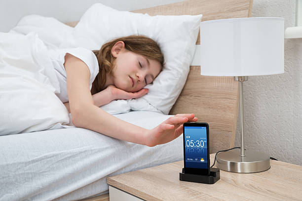 istock Girl On Bed Snoozing Mobile Phone Alarm 503913754