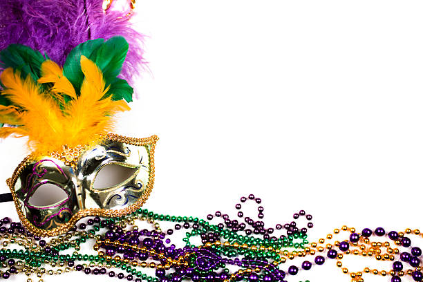 Mardi Gras background. Purple, gold, green, mask, beads. Mardi Gras background. Colorful feathers decorate the beautiful gold masquerade mask with beads in purple, gold, and green Mardi Gras colors. The objects are placed on a white background with copyspace to right. The Mardi Gras festival is held every year in New Orleans Louisiana, USA. purple and gold masquerade masks stock pictures, royalty-free photos & images