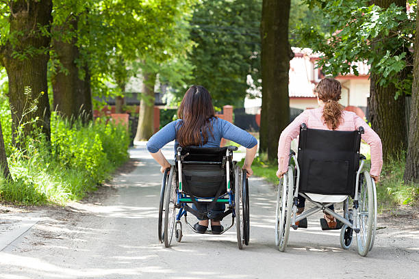 istock Two women on wheelchairs in park 503914337