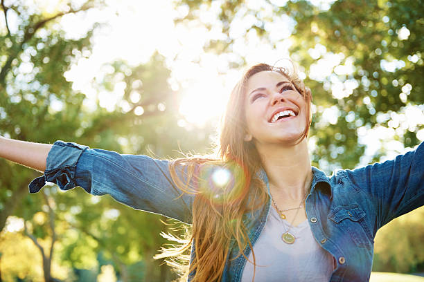 Young, free and wild A shot of a young woman standing outdoors with her arms outstretched free hug stock pictures, royalty-free photos & images