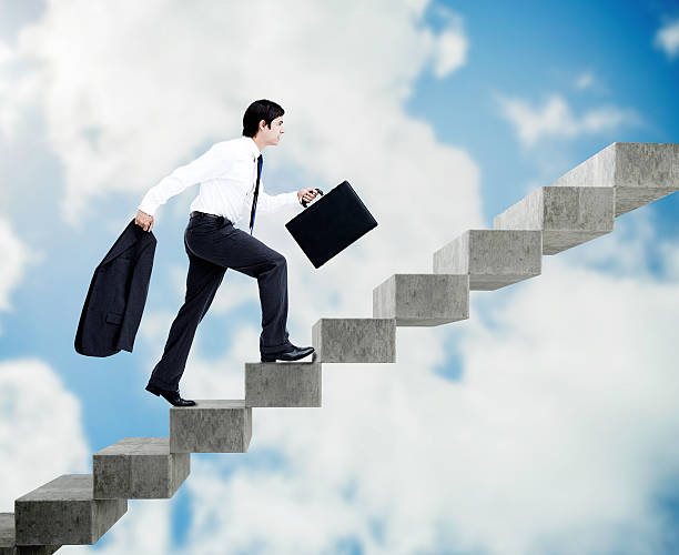 istock Young businessman climbing grey stairs 503917361